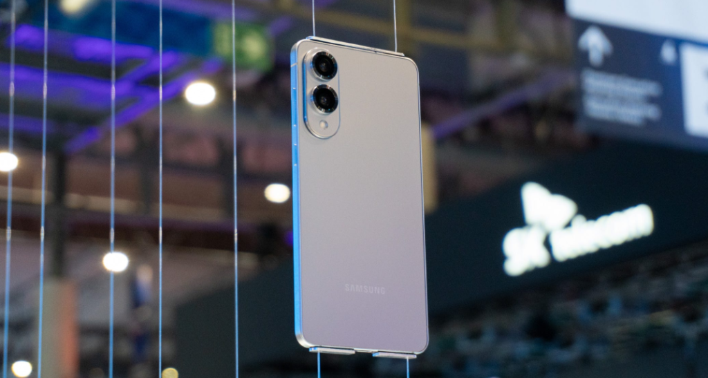 A Samsung phone with dual cameras is suspended on display at an event.