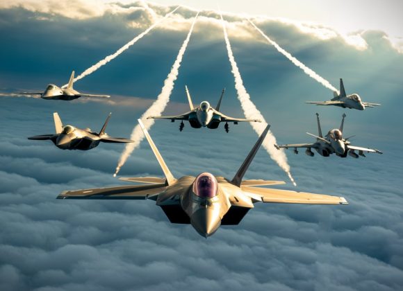 Air superiority fighter jets flying above the clouds with visible contrails, showcasing modern military aviation power under a dramatic sky.